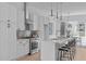 Modern white kitchen with stainless steel appliances, island with seating, and stylish pendant lights at 2002 Moody Ln, Durham, NC 27701
