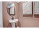 Powder room featuring pedestal sink, oval mirror, decorative art, and neutral paint at 2003 Regal Dr # 90, Durham, NC 27703