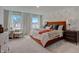 Spacious bedroom with a large bed, patterned wallpaper, plush carpet, and natural light at 2003 Regal Dr # 90, Durham, NC 27703