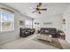 Cozy living room featuring leather sofas, a ceiling fan, and multiple windows at 2233 Kanata Mills Rd, Wake Forest, NC 27587