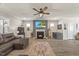 Cozy living room with fireplace, plush leather sofa, neutral walls, wood-look floors, and a ceiling fan at 2233 Kanata Mills Rd, Wake Forest, NC 27587