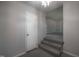 Well-lit hallway with carpeted steps leading to another room and a crystal chandelier illuminating the space at 2404 Pearces Rd, Zebulon, NC 27597