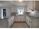 Bright kitchen featuring white cabinetry, countertop bar and large window at 2404 Pearces Rd, Zebulon, NC 27597