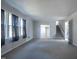 Spacious living room featuring large windows, neutral carpeting, and staircase access to upper level at 2404 Pearces Rd, Zebulon, NC 27597