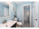 Updated bathroom with stylish vanity, framed mirror, blue walls, and shower room at 2409 Keith Dr, Raleigh, NC 27610