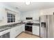 Well-lit kitchen with stainless steel appliances, white cabinets, and patterned granite countertops at 2409 Keith Dr, Raleigh, NC 27610