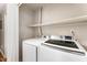 Efficient laundry area featuring a white washer and dryer with shelf for storage at 2409 Keith Dr, Raleigh, NC 27610