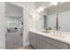 Bright bathroom showcasing a double vanity with gray cabinets and a view into a bedroom area at 2632 Jordan Pointe Blvd, New Hill, NC 27562
