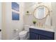 Chic powder room with blue vanity, gold fixtures, and designer mirror at 2632 Jordan Pointe Blvd, New Hill, NC 27562