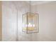 Close-up of a modern, geometric chandelier against a textured wallpaper background at 2632 Jordan Pointe Blvd, New Hill, NC 27562