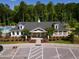 View of the community clubhouse with manicured landscaping and a well-maintained parking area at 2632 Jordan Pointe Blvd, New Hill, NC 27562