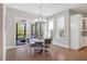 Sunlit dining area with hardwood floors, screened porch access, and elegant chandelier at 2632 Jordan Pointe Blvd, New Hill, NC 27562