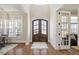Bright foyer featuring hardwood floors, a grand arched front door, and elegant trim details at 2632 Jordan Pointe Blvd, New Hill, NC 27562