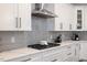 Close-up of kitchen with white cabinets, gray backsplash, modern appliances, and a gas range at 2632 Jordan Pointe Blvd, New Hill, NC 27562