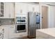 Modern kitchen features stainless steel appliances, white cabinetry and grey backsplash at 2632 Jordan Pointe Blvd, New Hill, NC 27562