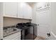 Laundry room with modern washer and dryer, granite sink and shaker cabinets at 2632 Jordan Pointe Blvd, New Hill, NC 27562