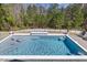 Beautiful backyard pool with a sun shelf and a view of the wooded area at 2632 Jordan Pointe Blvd, New Hill, NC 27562