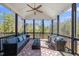 Inviting screened porch boasts comfortable seating, ceiling fan, and scenic views of the surrounding landscape at 2632 Jordan Pointe Blvd, New Hill, NC 27562