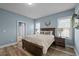 Bright bedroom featuring a large bed, two windows, and access to the ensuite bathroom at 310 Chub Lake St, Roxboro, NC 27573