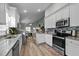 Modern kitchen with stainless steel appliances and breakfast bar that opens to the living and dining area at 310 Chub Lake St, Roxboro, NC 27573