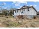 Rear exterior of fixer upper home with overgrown backyard needing maintenance at 3528 Cheek Rd, Durham, NC 27704