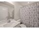 Well-lit bathroom features a large mirror, single sink vanity, toilet and shower with a patterned curtain at 368 Amber Acorn Ave, Raleigh, NC 27603