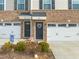 Charming townhome exterior with brick facade, two-car garage, and inviting front door adorned with a wreath at 368 Amber Acorn Ave, Raleigh, NC 27603