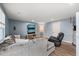 Bright living room featuring a gray sectional sofa, two TVs, and a comfortable black recliner at 368 Amber Acorn Ave, Raleigh, NC 27603
