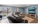 Comfortable living room with a sectional sofa, ottoman, two TVs, and a sliding glass door at 368 Amber Acorn Ave, Raleigh, NC 27603