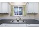 The kitchen features a stainless steel sink, white cabinets and yellow curtains at 3775 Guess Rd # 36, Durham, NC 27705