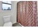 Bathroom with a toilet, a window and a shower with a unique shower curtain bringing a touch of elegance at 380 Grameta Ln, Lillington, NC 27546