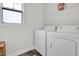 Bright laundry room featuring modern white appliances, window and overhead storage shelf for convenience at 380 Grameta Ln, Lillington, NC 27546
