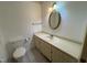 Bathroom featuring a neutral color palette with a vanity, toilet, and decorative mirror at 3901 Carson Dr, Sanford, NC 27332