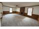 Expansive living room with a brick fireplace, paneling, neutral carpeting, and abundant natural light at 3901 Carson Dr, Sanford, NC 27332