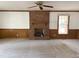 Spacious living room featuring a brick fireplace, carpet, and natural light from a window at 3901 Carson Dr, Sanford, NC 27332