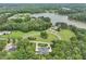 Aerial view displays the expansive property, lake, mature trees, and grand home with a circular driveway at 40 Park Meadow Ln, Youngsville, NC 27596