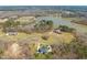 Aerial view of a lakeside estate featuring a grand home with a sprawling lawn and mature trees at 40 Park Meadow Ln, Youngsville, NC 27596