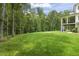 Spacious backyard showing off an open lawn and mature trees, creating a serene and private outdoor space at 40 Park Meadow Ln, Youngsville, NC 27596