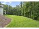 Spacious backyard showing off an open lawn and mature trees, creating a serene and private outdoor space at 40 Park Meadow Ln, Youngsville, NC 27596