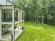 Expansive backyard featuring a covered porch, stone accents, and lush green lawn perfect for outdoor living at 40 Park Meadow Ln, Youngsville, NC 27596
