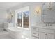 Bright bathroom features freestanding tub beneath a window and double vanity at 40 Park Meadow Ln, Youngsville, NC 27596