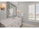Elegant bathroom featuring a marble countertop, decorative mirror, and plantation shutters at 40 Park Meadow Ln, Youngsville, NC 27596