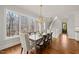 Light-filled dining room featuring wood floors, chandelier, and mature tree views at 40 Park Meadow Ln, Youngsville, NC 27596