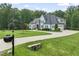 Charming two-story home with light blue siding, black shutters, well-manicured lawn, and a circular driveway at 40 Park Meadow Ln, Youngsville, NC 27596