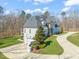 Stunning two-story home with a gray roof, stone accents, manicured lawn, and attached three-car garage at 40 Park Meadow Ln, Youngsville, NC 27596