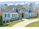 A luxurious two-story home with stone and siding, manicured landscaping, and a circular driveway at 40 Park Meadow Ln, Youngsville, NC 27596