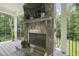 Close up of the stone fireplace on the covered patio with outdoor television at 40 Park Meadow Ln, Youngsville, NC 27596