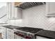 Close-up of modern gas range with stainless steel hood and white herringbone backsplash at 40 Park Meadow Ln, Youngsville, NC 27596
