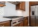 Gourmet kitchen with white tile backsplash, stainless steel appliances, and custom wood cabinetry at 40 Park Meadow Ln, Youngsville, NC 27596