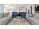 Open living room with two couches, two blue armchairs, and stairway to other rooms at 40 Park Meadow Ln, Youngsville, NC 27596